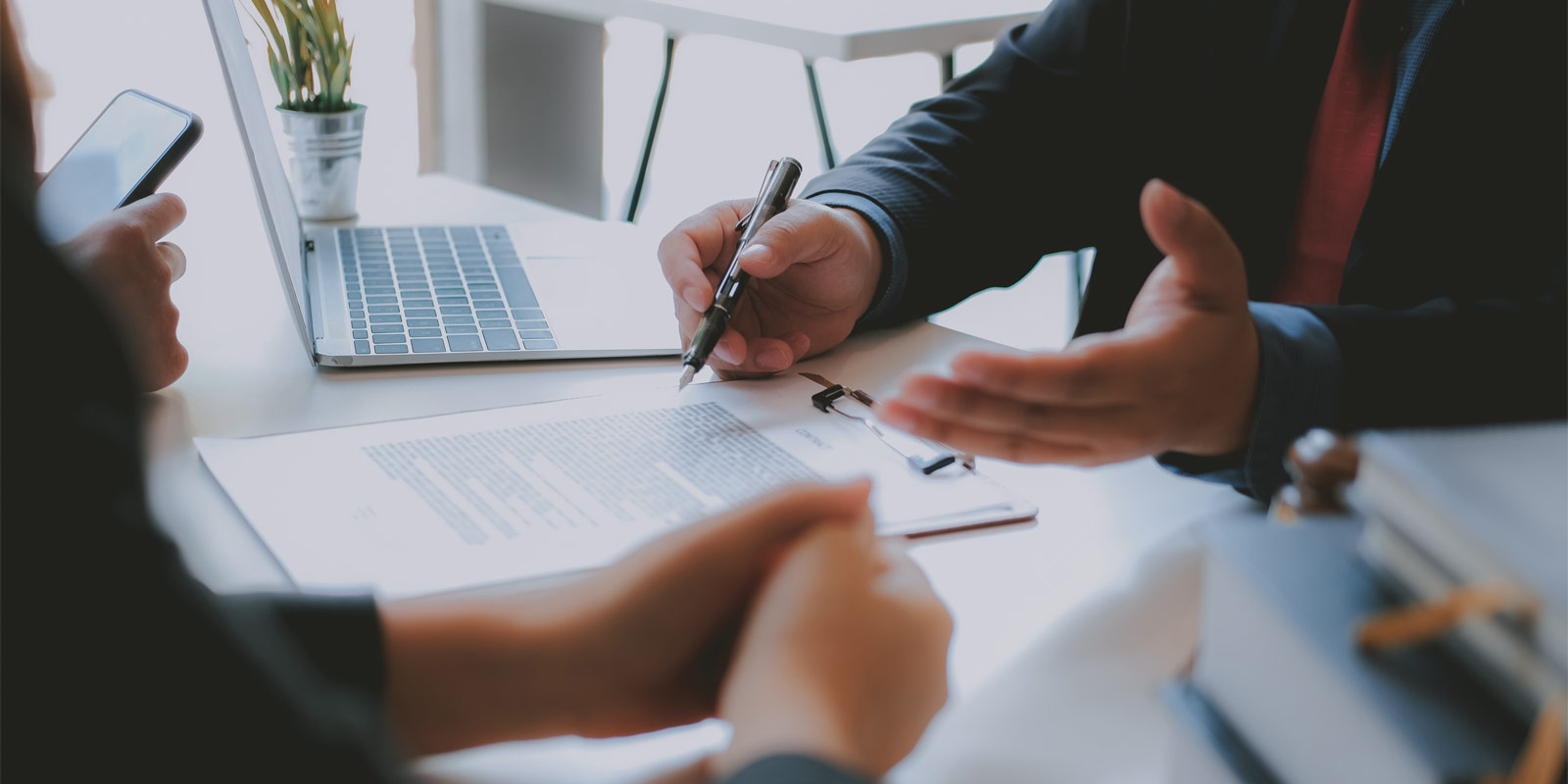 a specialty life insurance broker signing paperwork with a client